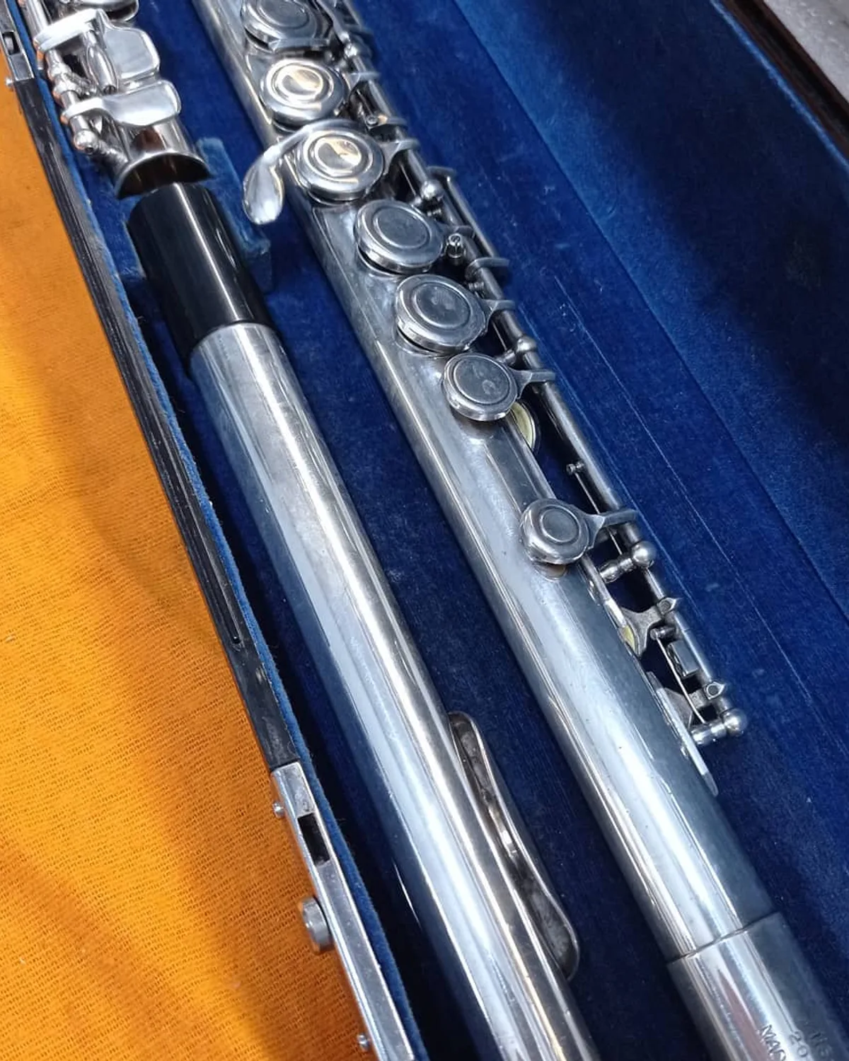 Flauta transversal prateada na oficina da Musicaltec
